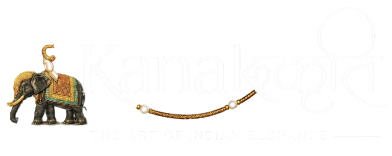 A small carved elephant figurine with a rider, decorated with a multicolored saddle and gold-toned details, shown beside a gold-toned beaded necklace on a plain white background. A faint 'Kanaloo' brand watermark is visible across the center.